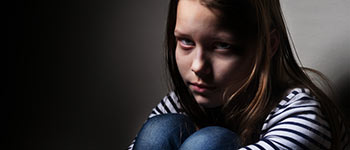 Photo of child in a dark place, depicting violence against children
